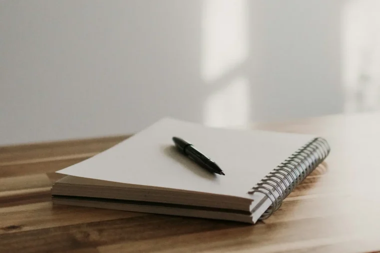 kelly-sikkema-ChsnZBAX6wA-unsplash Notebook and a pan on a wooden table